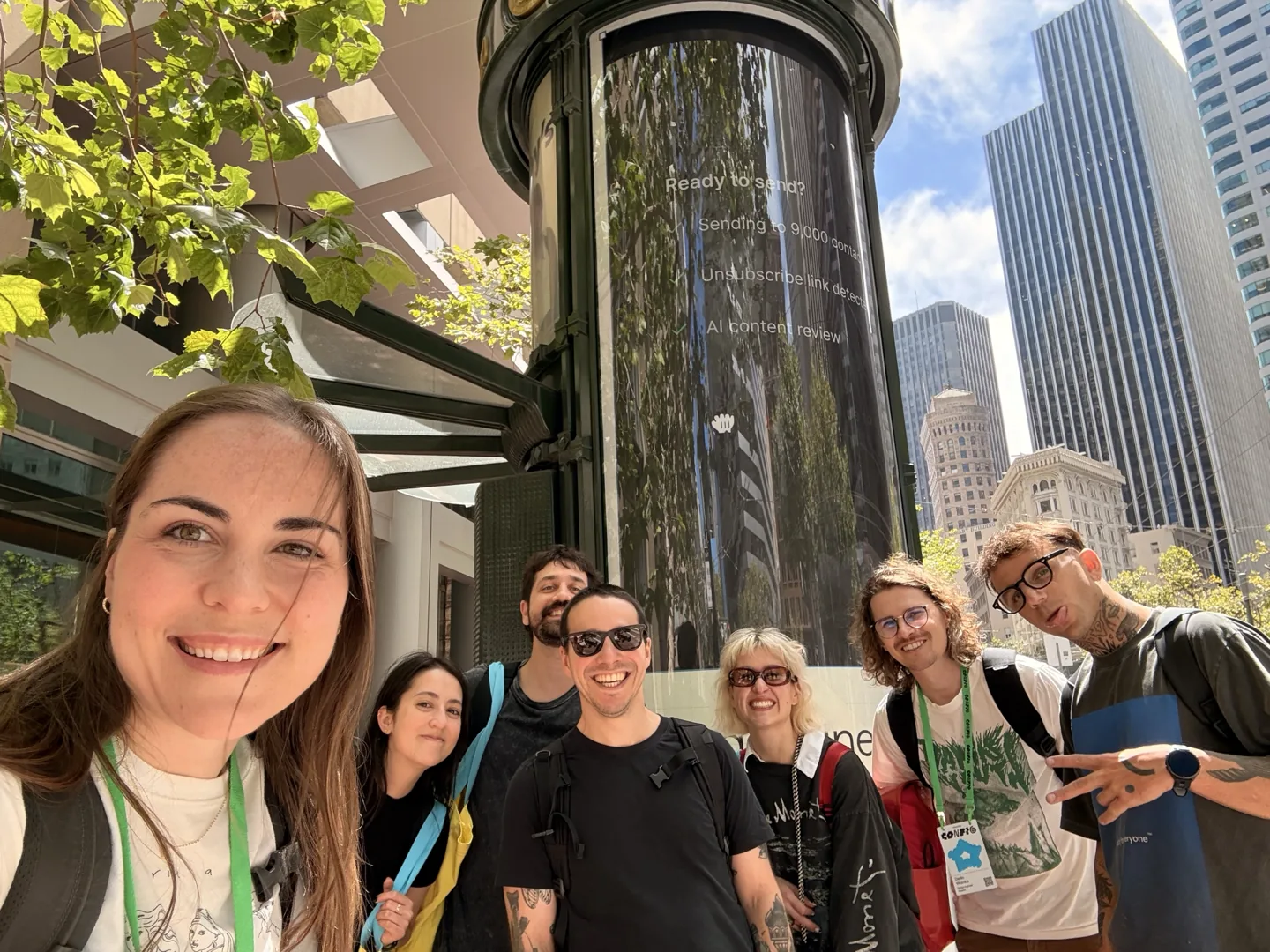 People in front of a tower beside a Paper newsstand
