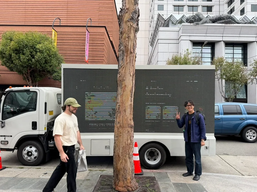 Two people on the sidewalk beside a Paper truck